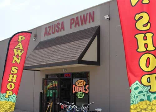 A pawn shop with grey walls and 2 red banners hanging on the wall